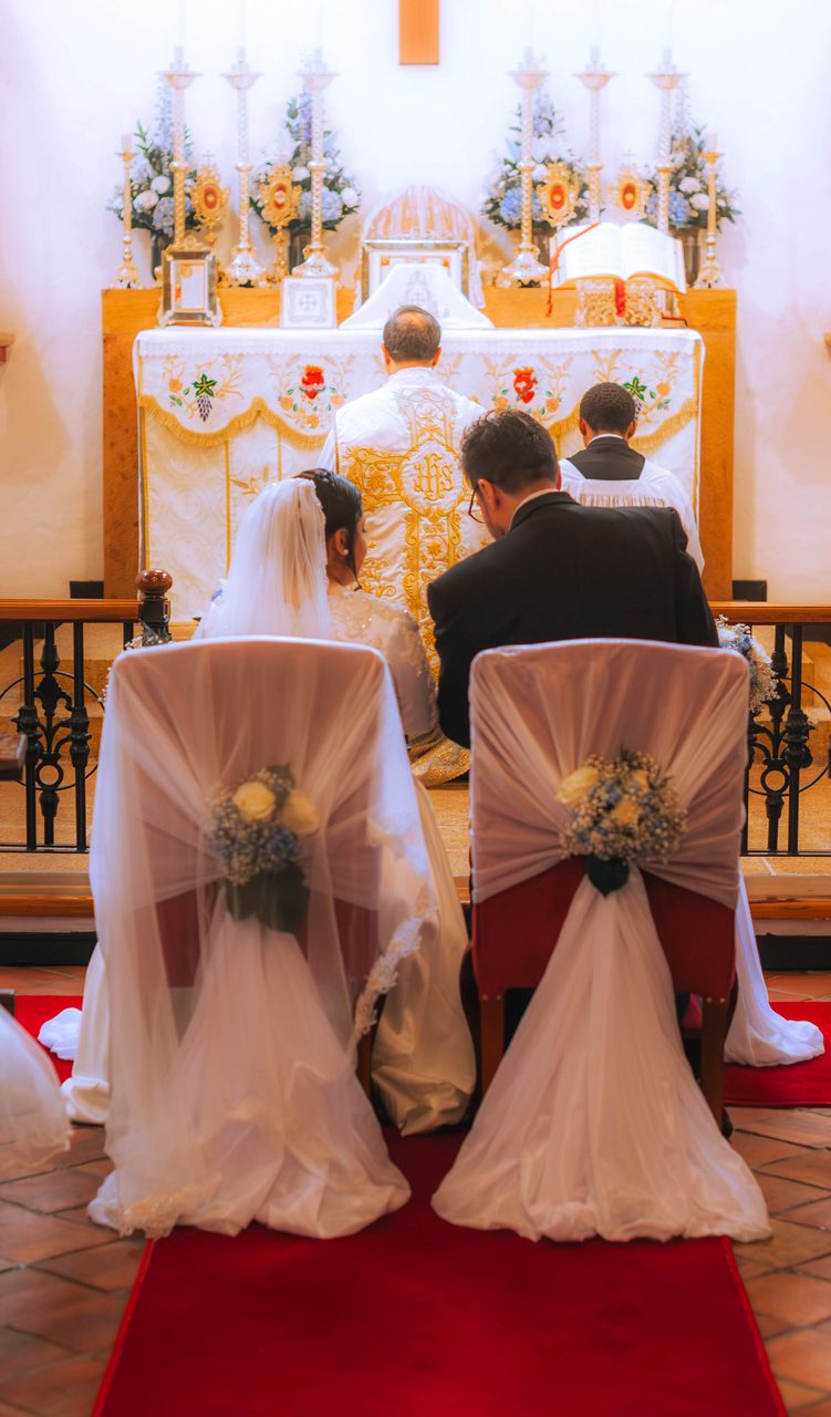 Gli sposi seduti davanti all'altare, visti da dietro